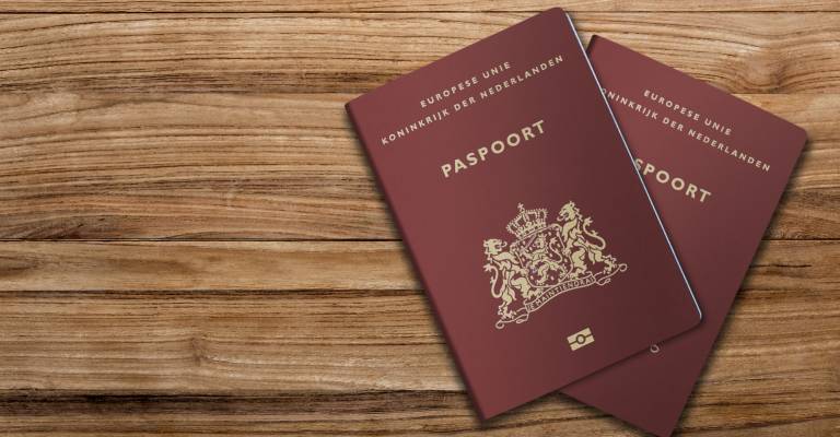 2 Nederlandse paspoorten op een houten achtergrond