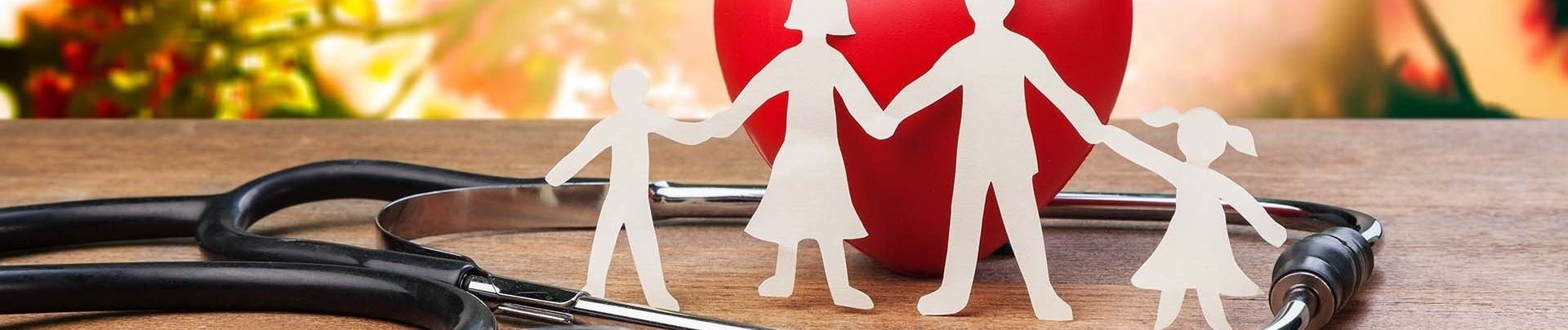 Gezondheid silhouetten van een gezin hand in hand met een stethoscoop en een rood hart